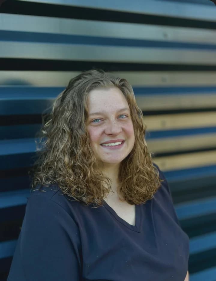 Portrait of Gretchen smiling against a blue-and-dark background